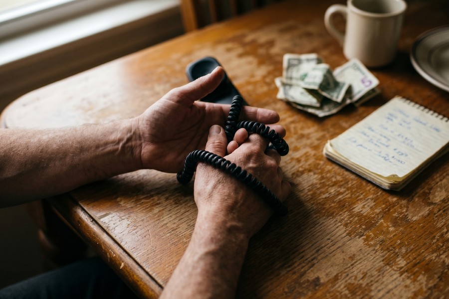 Freelancer reviewing monthly health insurance costs on a financial planning spreadsheet at a home office desk