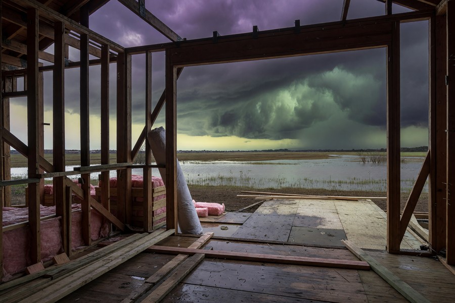 Builders risk insurance policy document beside a home renovation blueprint and hard hat