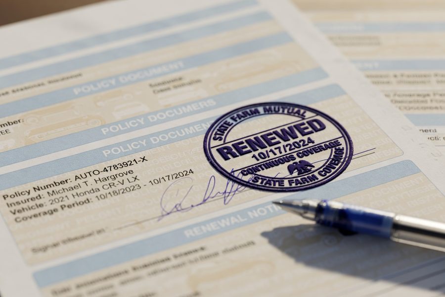 Driver reviewing car insurance policy documents and discount eligibility checklist at a desk