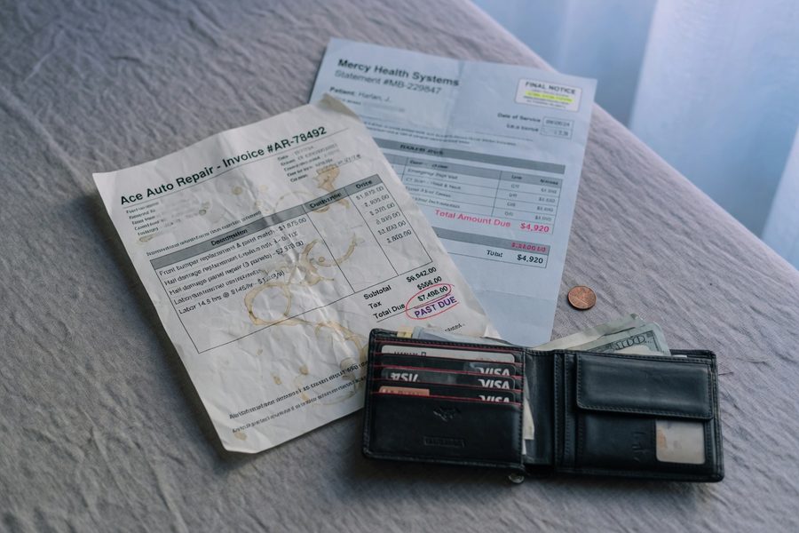 Insurance agent reviewing auto policy documents with client at office desk