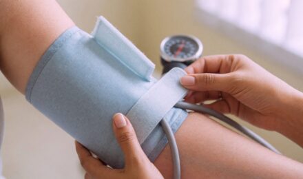 Paramedical examiner taking blood pressure reading during term life insurance medical exam
