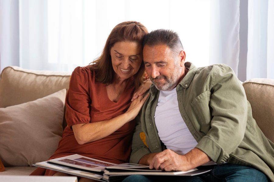 Dual self-employed couple reviewing financial documents at kitchen table