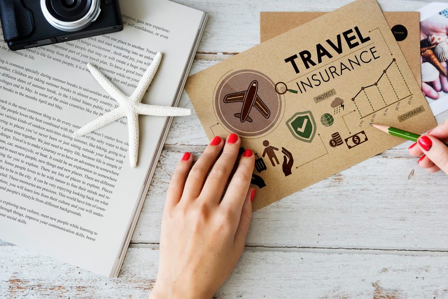 Traveler reviewing a travel insurance policy document on a laptop at the airport.