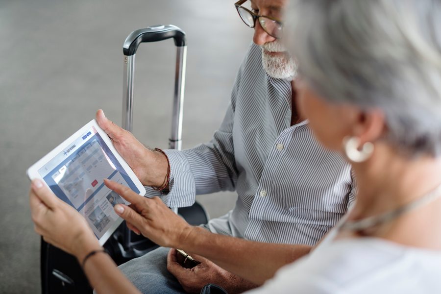 Senior couple reviewing travel insurance documents at airport