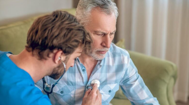 34-year-old man in Arizona reviewing term life insurance policy documents for $800,000 coverage with heart condition