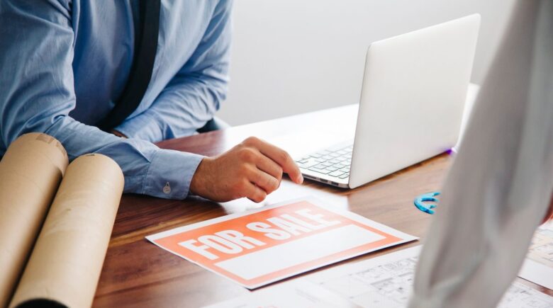 Freelance graphic designer reviewing contract and liability insurance documents at desk in Austin office